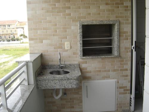 baño con lavabo en una pared de ladrillo en Apartamento em Praia dos Ingleses, en Florianópolis