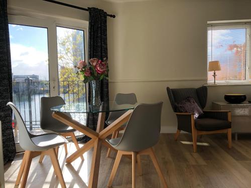 a dining room with a glass table and chairs at Lagan View - the perfect location in the city in Belfast