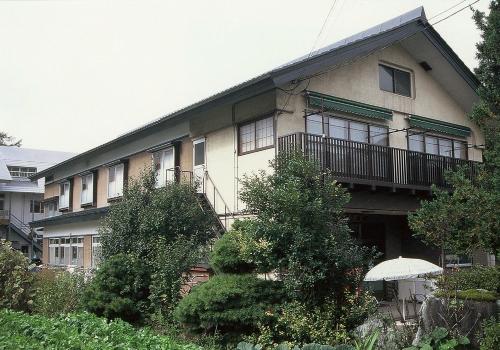 a building with an umbrella in front of it at Takanoya in Yuzawa