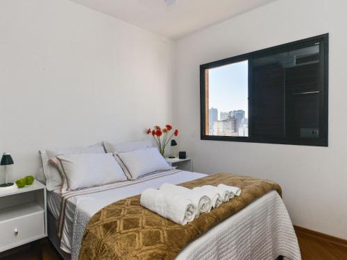 1 dormitorio con 1 cama con 2 toallas en Apartamento Aconchegante com Vista Incrível, Piscina e Vaga, en São Paulo