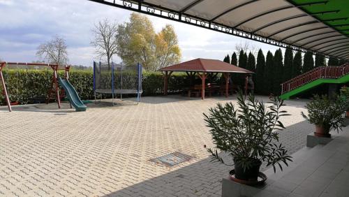 a playground with a slide and a swing set at Apartman Taktik in Veľký Meder