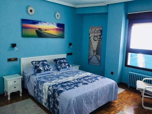 - une chambre bleue avec un lit et une fenêtre dans l'établissement Mirandoalmar, à Gijón