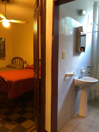 Un baño con lavabo y cama. en Hotel Aguirre, en Mina Clavero