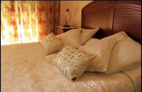 カストロ・ウルディアレスにあるVilla Maguanaのベッド(白いシーツ、枕付)