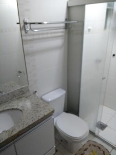 a bathroom with a toilet and a sink and a shower at Flat209 Veredas Rio Quente Particular in Rio Quente