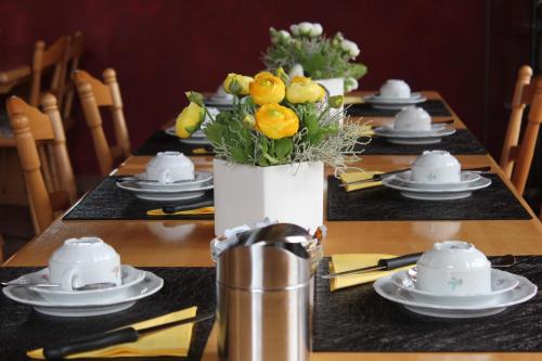 a table with a centerpiece of flowers in a vase at Altstadt-Residenz Manz in Wachenheim an der Weinstraße