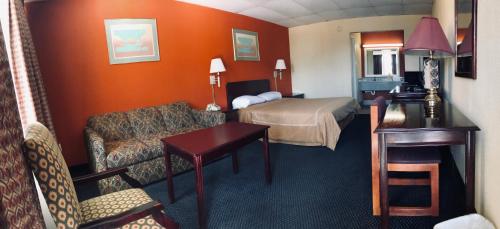 a hotel room with a bedroom with a bed and a couch at Executive Inn Texarkana in Texarkana