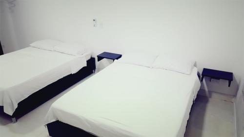 duas camas sentadas uma ao lado da outra num quarto em Apartamentos Hilal House em San Andrés