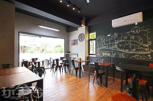 um restaurante com mesas e cadeiras e uma parede de quadro negro em Ark stay方舟文旅山嵐新館溜滑梯商務民宿 em Jiji