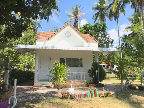 a white house with palm trees in front of it at Wandee Resort Bankrut in Ban Krut