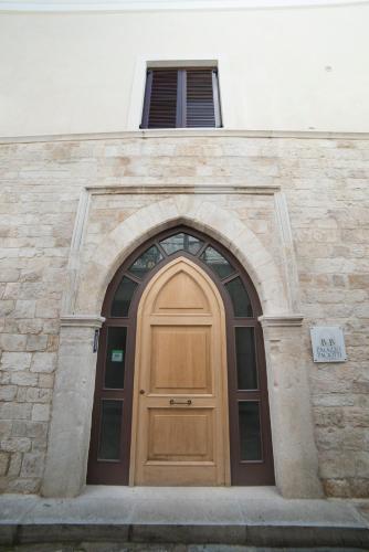a wooden door on a building with a window at B&B Palazzo Paciotti in Trani