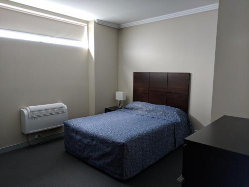 a small bedroom with a bed and a window at The Bexley Motel in Sydney
