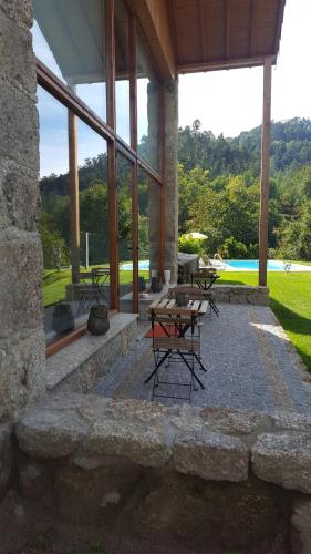 a patio with tables and chairs in front of a building at Cantinho da Pedra in Vieira do Minho