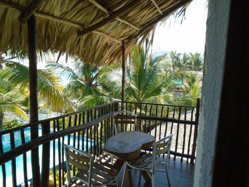 a balcony with a table and chairs and the ocean at Marbella Eco Lodge in Monterrico