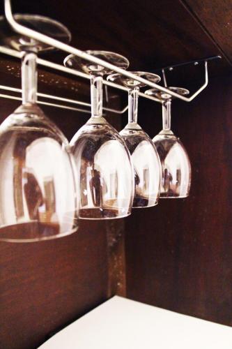 a group of wine glasses hanging from a rack at Kannur Beach view Homestay in Kannur