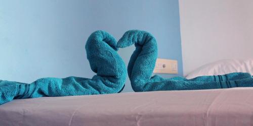 two snakes made out of blue towels on a bed at Kannur Beach view Homestay in Kannur