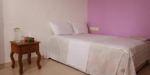 a small bedroom with a bed and a night stand at Kannur Beach view Homestay in Kannur
