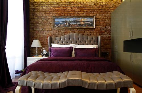 a bedroom with a large bed with a brick wall at Frida Suites in Istanbul
