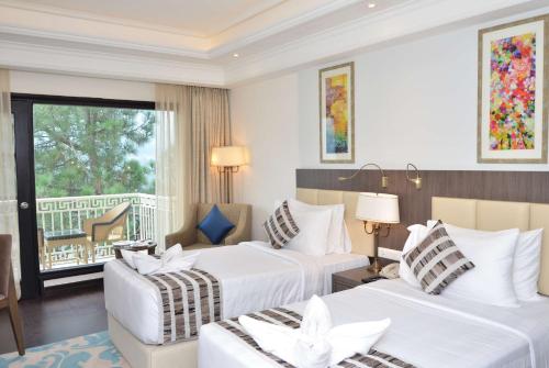 a hotel room with two beds and a balcony at Ramada by Wyndham Kasauli in Kasauli