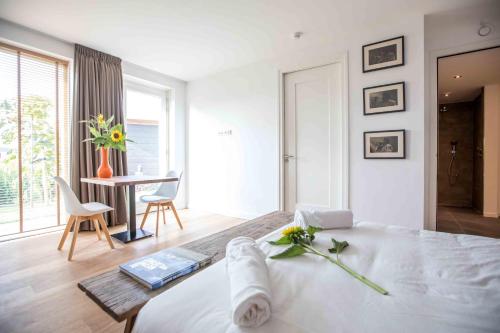 een witte slaapkamer met een bed en een tafel met stoelen bij Amsterdam Area Residence Oosterwold in Almere