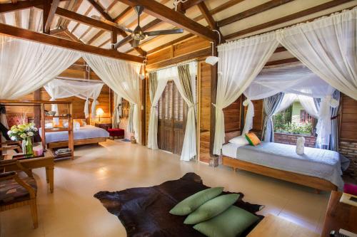 a bedroom with two beds in a room with a ceiling at Cat Tien Jungle Lodge in Cat Tien