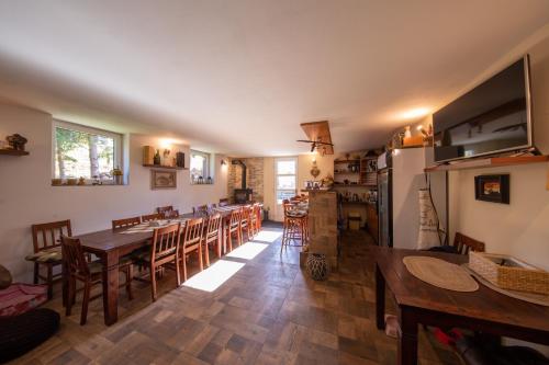 a dining room with tables and chairs and a kitchen at Apartmány Chalupa "Pod lípou" in Staré Město