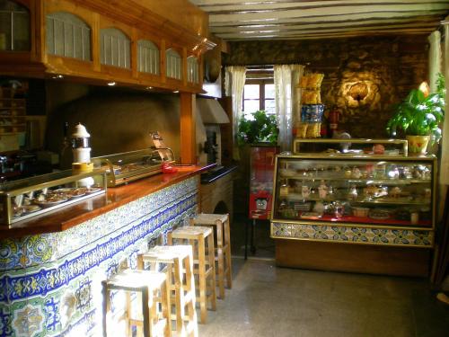 a kitchen with a counter and stools in a restaurant at Hotel Puerta Romeros in Burgos