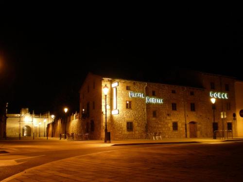 a building with lights on the side of it at night at Hotel Puerta Romeros in Burgos
