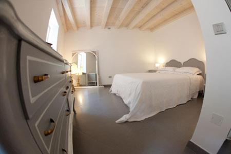 Parona di ValpolicellaにあるRomeo e Giulietta Appartamentiの白いベッドルーム(ベッド1台、窓付)