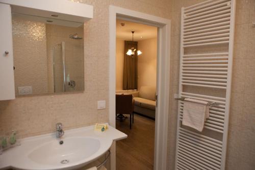 a bathroom with a sink and a mirror at Familiehotel Soll Cress Koksijde in Koksijde