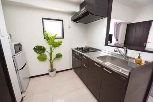 eine Küche mit einer Spüle und einem Kühlschrank in der Unterkunft EX Itoman Apartment 501 in Itoman