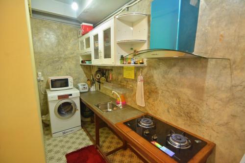 a small kitchen with a sink and a washing machine at The Corner's unique house in Chiang Mai