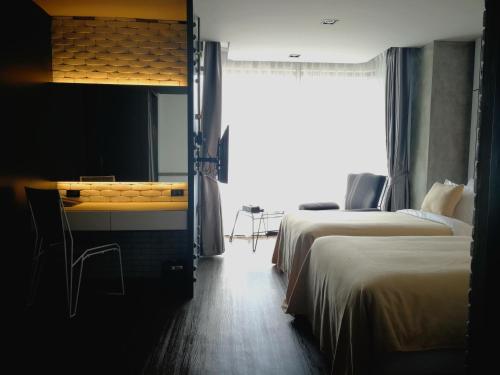 a hotel room with two beds and a window at S Hadyai Hotel in Hat Yai