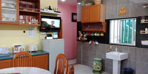 a kitchen with a sink and a tv on a wall at Jazepuri - Jaze 1 in Kuching