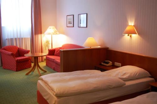 a hotel room with a bed and a chair at Hotel Frankenbach in Eltville