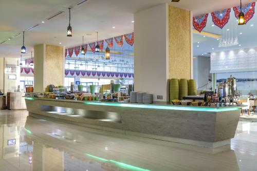 a restaurant with a bar in a large room at Radisson Blu Resort Jizan in Jazan