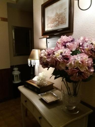 a vase of flowers on a table in a room at Hostal Rural Moratín in Pastrana