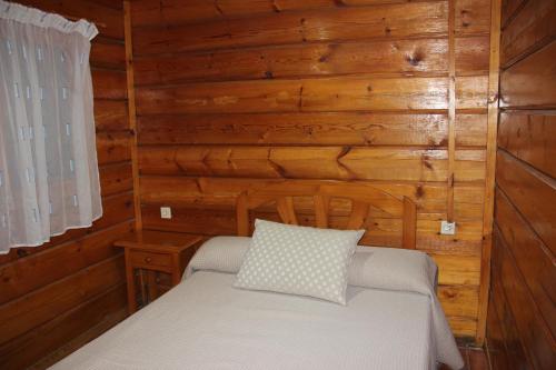 a bedroom with a bed in a log cabin at Camping La Puerta in Moratalla