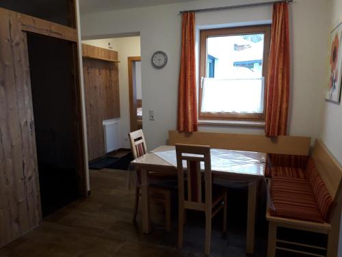 a dining room with a table and chairs and a window at Ferienwohnung Eiterer in Kauns