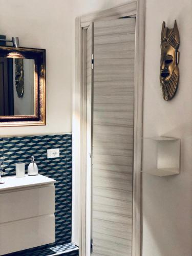 a bathroom with a door with a mask on the wall at Palazzina300 in Treviso