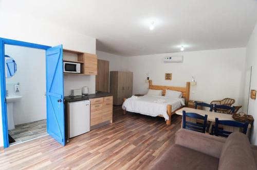 a bedroom with a bed and a kitchen and a couch at Lithos Studios in Voroklini