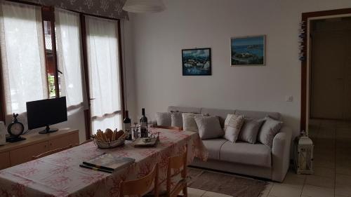 - un salon avec un canapé et une table dans l'établissement Villa Gardenia, à Eraclea Mare