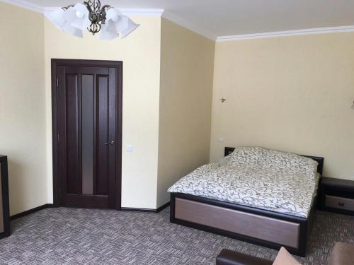 トラスコヴェッツにあるАпартаменти Помірецька/Шашкевичаのベッドルーム1室(ベッド1台付)、茶色のドア