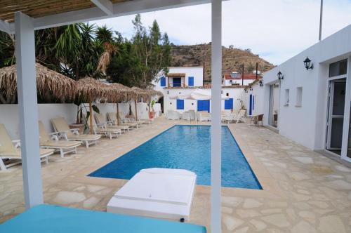 a swimming pool with chairs and a resort at Lithos Studios in Voroklini