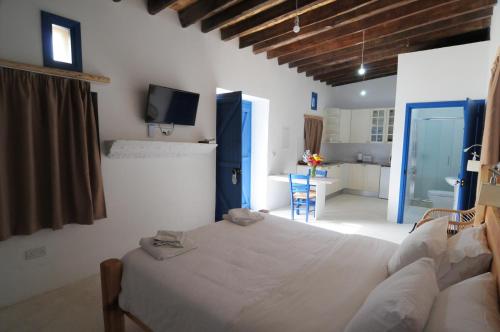 a bedroom with a large white bed and a tv at Lithos Studios in Voroklini