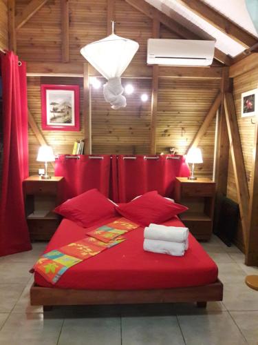 Un dormitorio con una cama roja con sábanas rojas. en Fetay Jaune, en Baie-Mahault