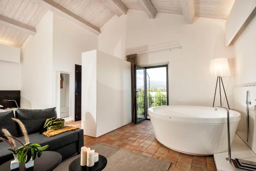 a large white bath tub in a living room at Ramo d'Aria Etna Boutique Hotel in Giarre