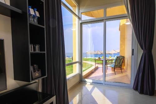 a room with a large window with a view of the ocean at Royal Beach Hotel & Resort in Dibba