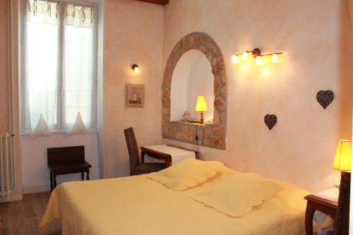 a bedroom with a bed and a mirror on the wall at Le Manoir in Mornas