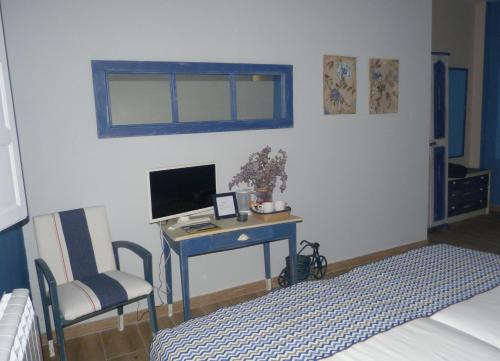 a bedroom with a desk with a computer and a chair at Casa de Tintas in Cuenca